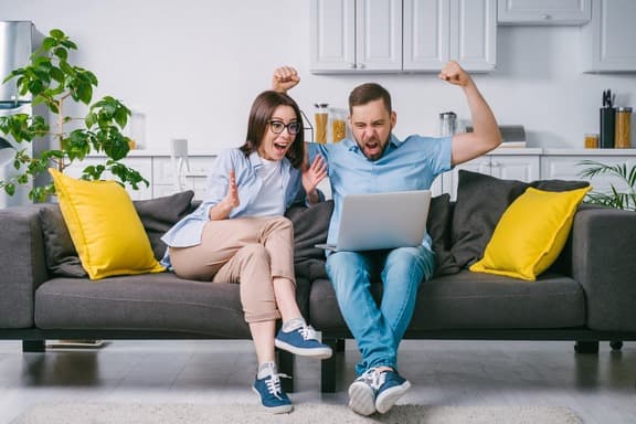A man and a women looking delighted watching something
