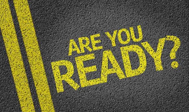 The phrase "ARE YOU READY?" in bold yellow lettering on a textured black surface with yellow lines.